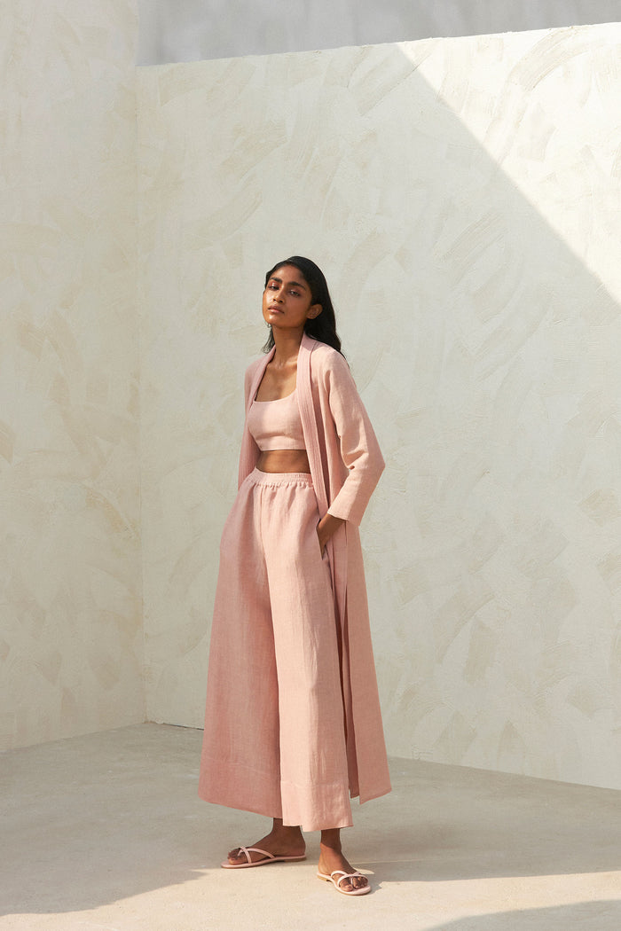 Woman wearing a pink crop top, cardigan and wide-leg trousers