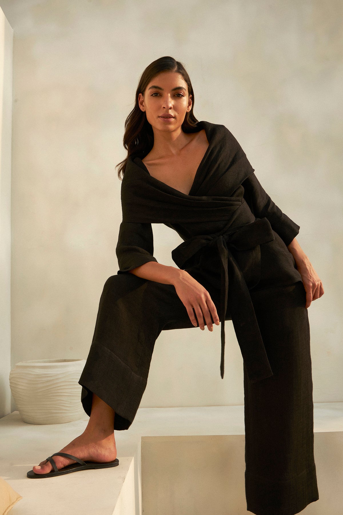 Woman wearing a black wrap top and wide-leg trousers